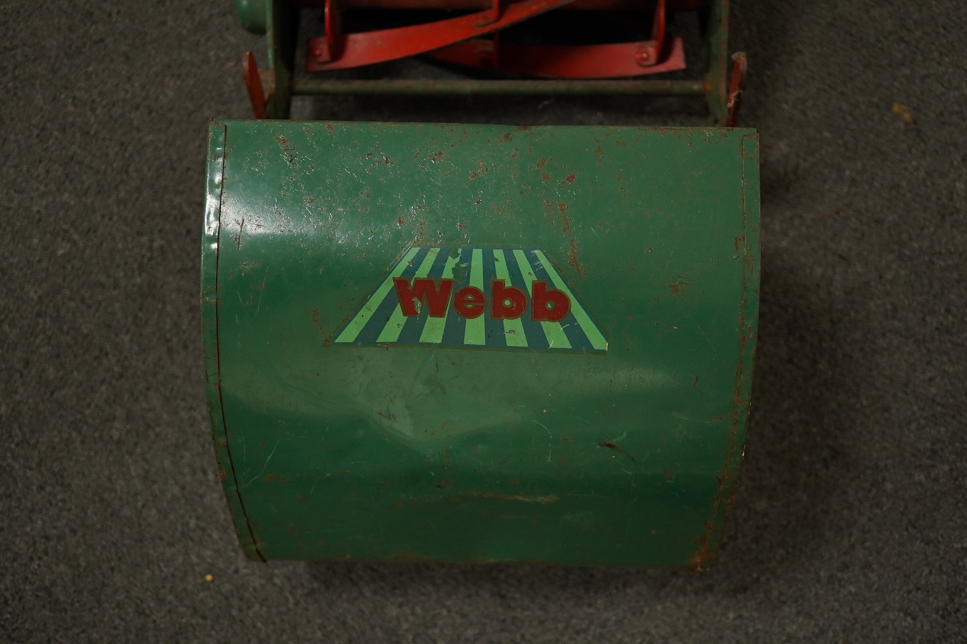 A late 1950s child's Webb push along scale model lawn mower, with Webb transfers to the grass box and side of the body and rubber handles, 63cm high. Condition - fair, some surface rust and general age related damage and